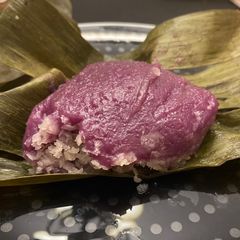 A picture of Purple yam in banana leaves (kue bugis).