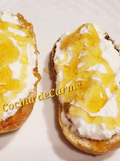 Una foto de Tostadas con mermelada de naranja, requesón y miel de flores