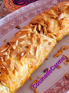Una foto de Brazo de hojaldre crujiente relleno de queso, sobrasada y miel