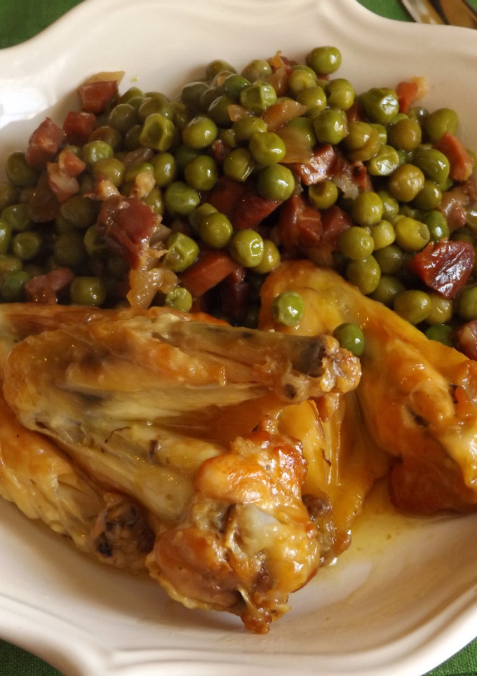 Una foto de Alitas de pollo guisadas en salsa de azafrán con guisantes al jamón