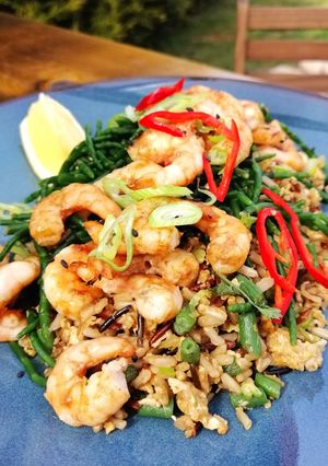 A picture of Grilled prawns with egg wild fried rice and samphire.