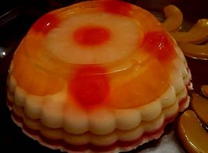 Una foto de Gelatina encapsulada con melocotones, cerezas y piña