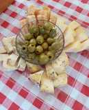 Plato de quesos y aceitunas verdes deshuesadas