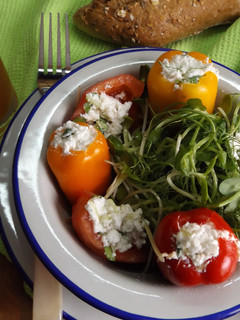 Una foto de Pimientitos rellenos con queso de cabra y brotes de calabaza y de guisantes