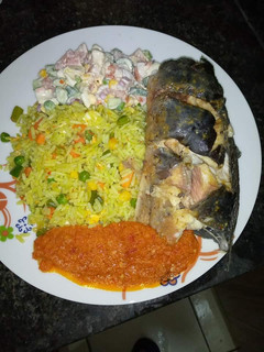 A picture of Fried rice stew, garden salad, frying cat fish.