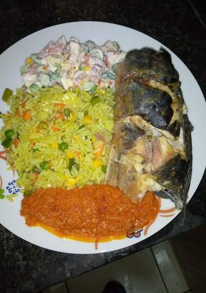 A picture of Fried rice stew, garden salad, frying cat fish.