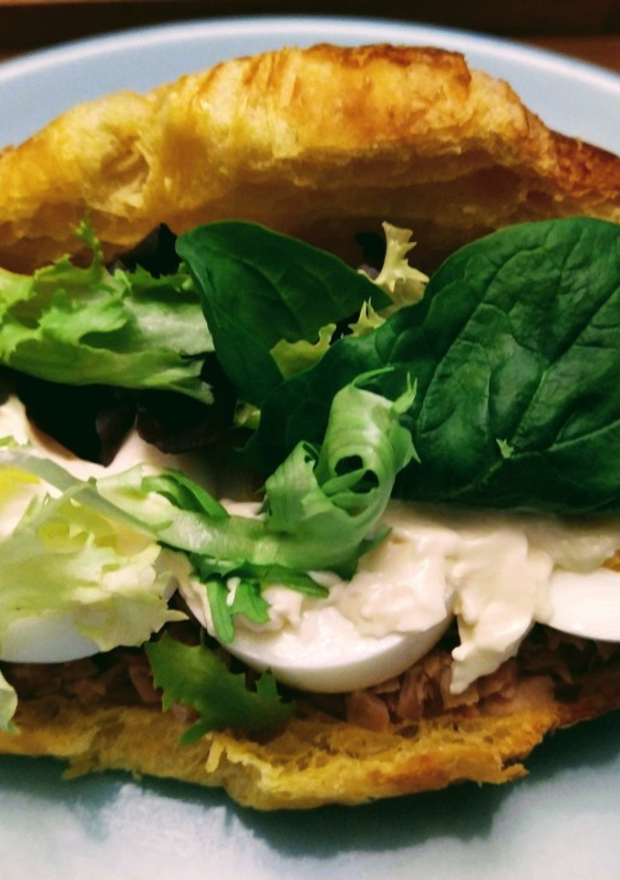 Una foto de Croissant con atún, huevo y lechuga variada