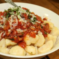 A picture of Ricotta gnocchi w' bacon & tomato sauce.
