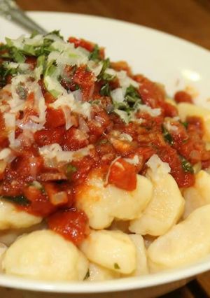 A picture of Ricotta gnocchi w' bacon & tomato sauce.