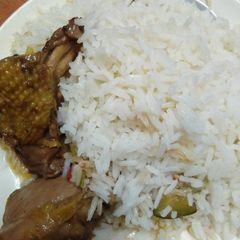 A picture of Stewed chicken served with rice.