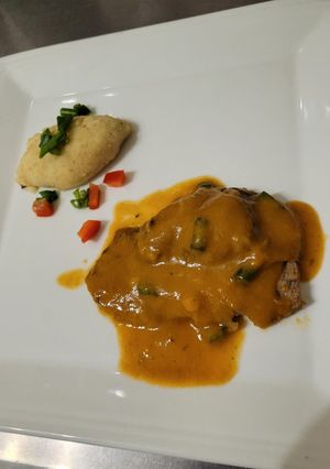 Una foto de Paleta al curry con croquetas de papas