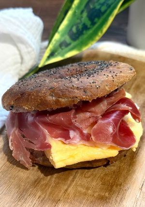 Una foto de Bagel de arándanos con tortilla francesa, jamón serrano y queso