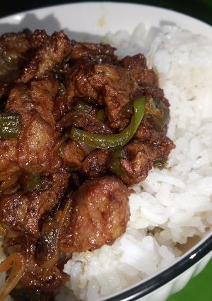 A picture of Onion and green pepper beef stir fry with rice.