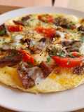 Tortilla abierta de rovellons, emmental y tomate