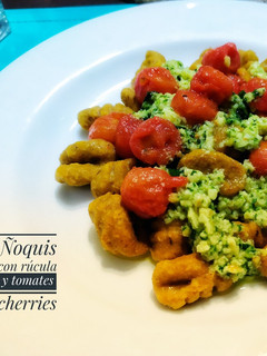 Una foto de Ñoquis con pesto de rúcula y tomates cherries