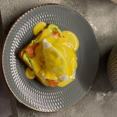 Breakfast poached egg toast with avocado cream, salmon and hollandaise A picture of Breakfast poached egg toast with avocado cream, salmon and hollandaise.