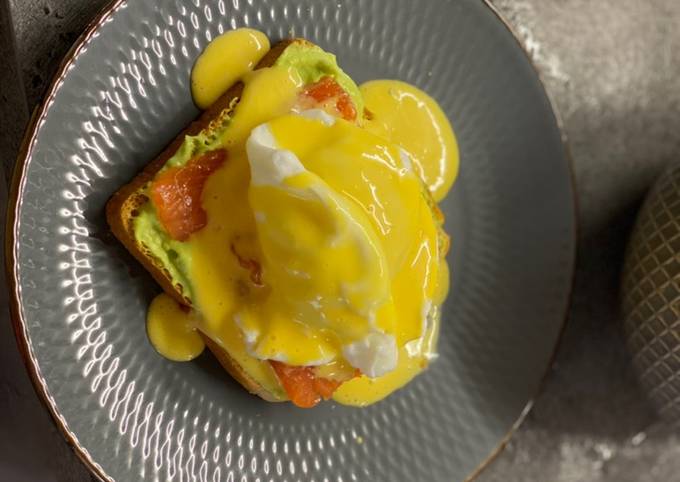 Breakfast poached egg toast with avocado cream, salmon and hollandaise