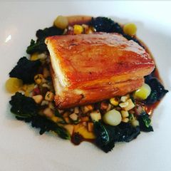 A picture of Apple glazed braised Pork belly with fricasse of sweetcorn, lardons and fregola pasta.