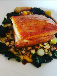 A picture of Apple glazed braised Pork belly with fricasse of sweetcorn, lardons and fregola pasta.