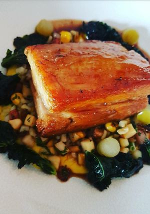 A picture of Apple glazed braised Pork belly with fricasse of sweetcorn, lardons and fregola pasta.