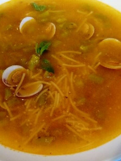 Una foto de Sopa de espárragos salvajes con almejas y fideitos, y toque de hierbabuena y cítrico.