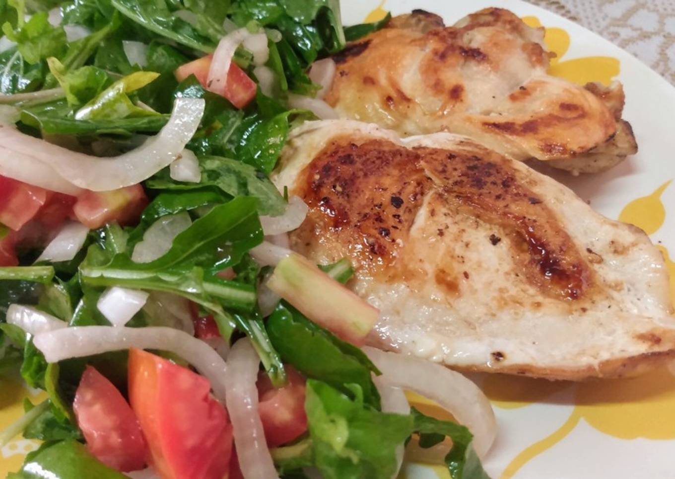 Bifes de pollo con ensalada de rúcula y cebolla curada