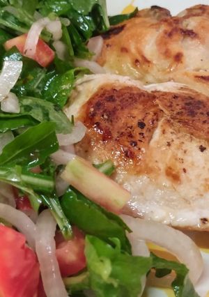 Una foto de Bifes de pollo con ensalada de rúcula y cebolla curada