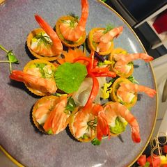 A picture of Guacamole sauce with prawn and corn tortilla.