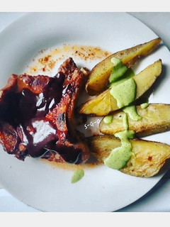 Una foto de Cerdo con barbecue y papas con salsa verde
