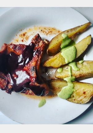 Una foto de Cerdo con barbecue y papas con salsa verde