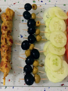 Una foto de Pincho de cerdo y ensalada de tomate