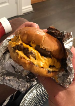 A picture of A gooey, naughty, cheeseburger.