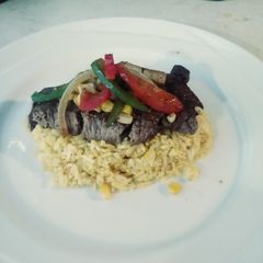 A picture of Steak & Turmeric Rice with Sauteed Corn, Onions & Pepprs.
