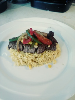 A picture of Steak & Turmeric Rice with Sauteed Corn, Onions & Pepprs.