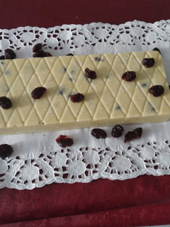 Una foto de Turrón de chocolate blanco con arándanos, y pistachos