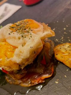 Una foto de Huevos rotos con pimientos confitados y jamón crujiente e ibérico