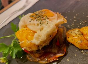 Una foto de Huevos rotos con pimientos confitados y jamón crujiente e ibérico