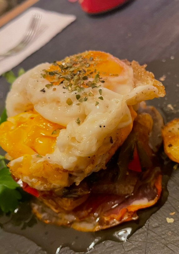 Una foto de Huevos rotos con pimientos confitados y jamón crujiente e ibérico