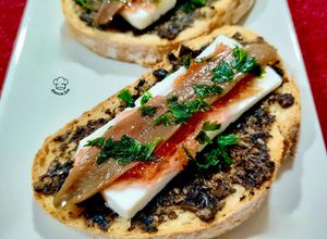 Una foto de Tosta trufada con queso fresco, anchoa y mermelada de pétalos de rosa