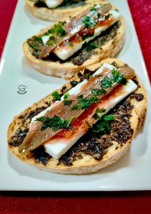 Una foto de Tosta trufada con queso fresco, anchoa y mermelada de pétalos de rosa