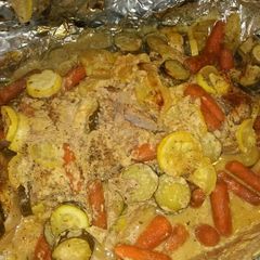 A picture of Foil wrapped honey mustard pork loin with zucchini, squash, and baby carrots.