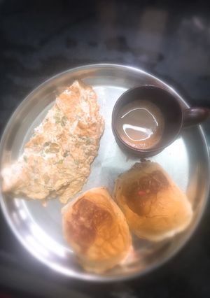 A picture of Sweet Maska Bun with omelette and tea.