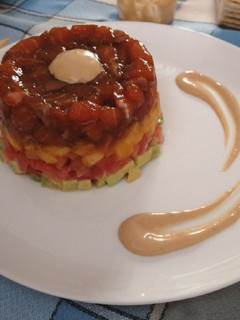 Una foto de Tartar de salmón, mango, tomate y aguacate