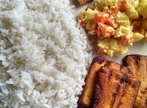 Una foto de Pollo al ajillo con arroz, ensalada y tajada
