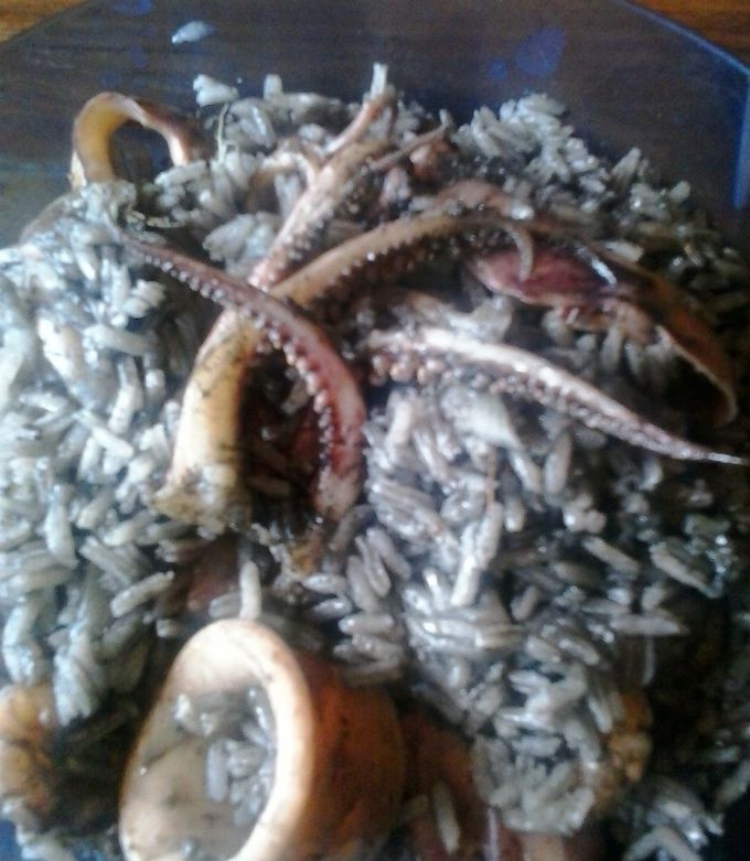 Una foto de Arroz con camarones y calamares en su tinta