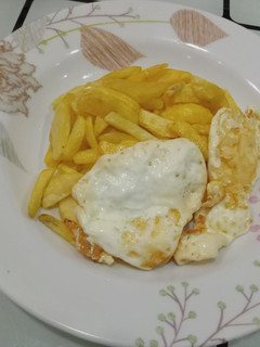 A picture of Fried potatoes with poached eggs.