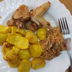 A picture of Roasted potatoes served with kienyenji chicken and cabbage.