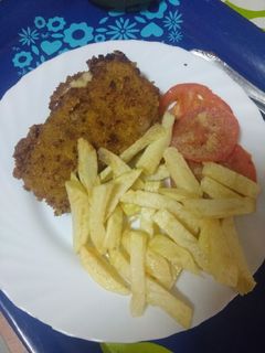 Una foto de Cachopo de cinta de lomo con tomate provenzal y papas fritas