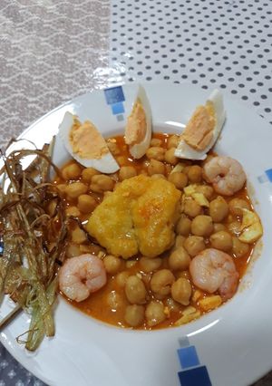 Una foto de Garbanzos guisados con bacalao gambas y crujiente de cebolleta