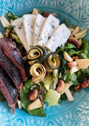 Une photo de Salade verte magret de canard aux 3 noix grillées et roquefort